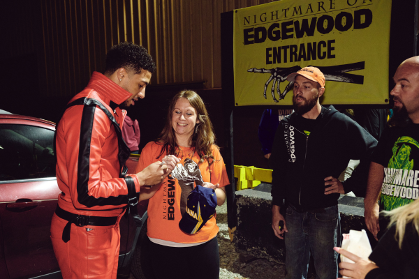 Tyrses Haliburton autographs a ball cap at Nightmare on Edgewood